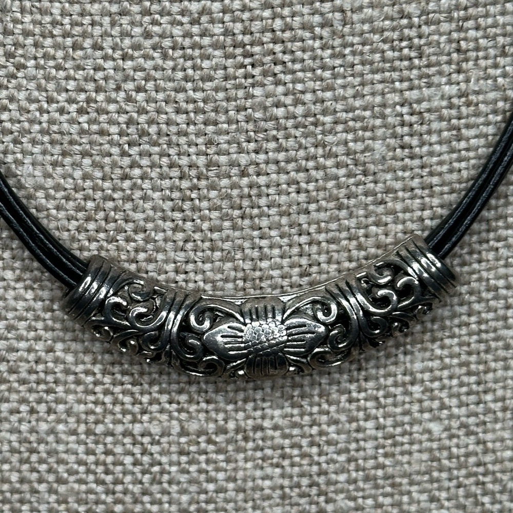 Leather band short necklace with adjustable length.